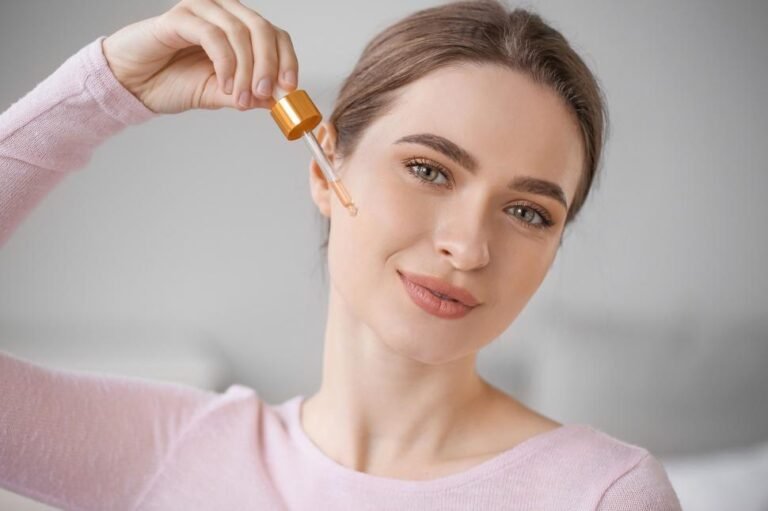 Woman applying hyaluronic acid serum dropper on face routine
